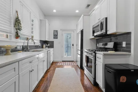 a large kitchen with stainless steel appliances granite countertop a stove a sink and a refrigerator