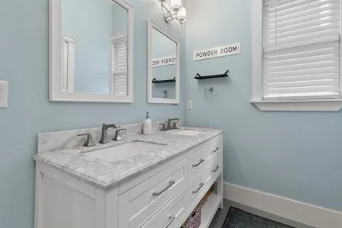 a bathroom with a granite countertop sink and a mirror
