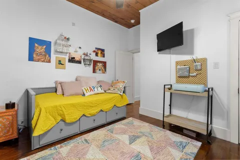 a living room with furniture a lamp and a flat screen tv