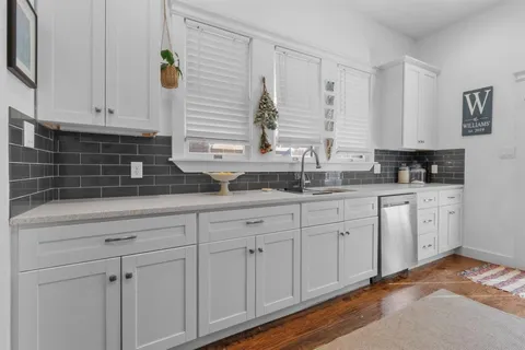 a kitchen with white cabinets and white appliances