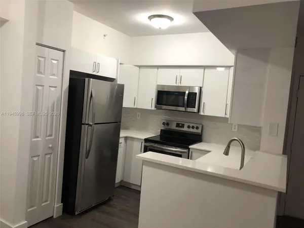a kitchen with stainless steel appliances a refrigerator microwave and sink