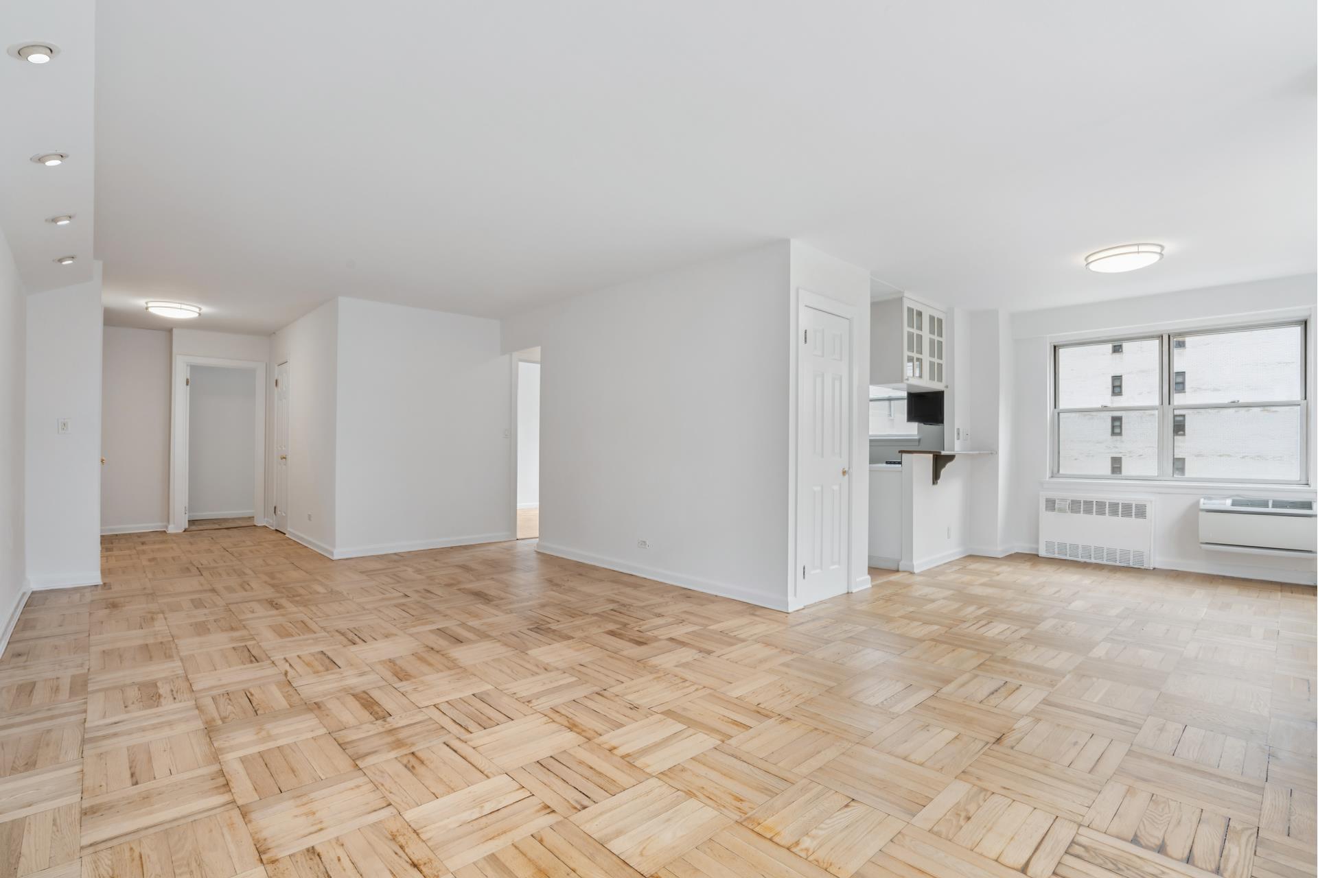 300 East 71st Street, Unit 9G Manhattan, NY 10021 - Photo 5 of 17 a view of empty room with kitchen and window