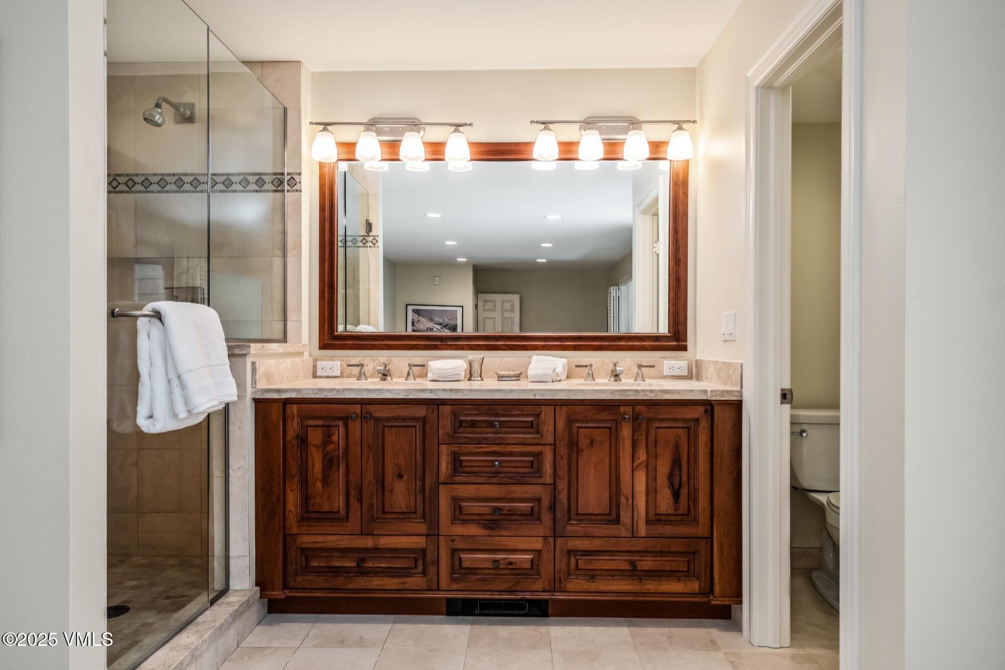 945 Red Sandstone Road, Unit A5 Vail, CO 81657 - Photo 22 of 38 a bathroom with a sink a mirror and a shower