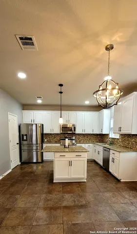 a kitchen with stainless steel appliances a stove a sink cabinets and refrigerator