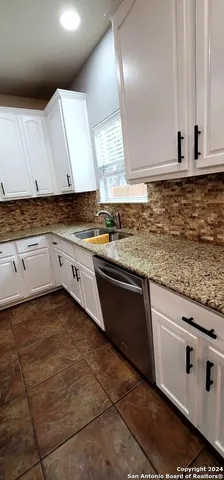 a kitchen with granite countertop a sink and cabinets