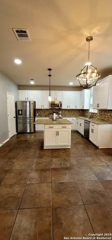 a kitchen with stainless steel appliances a stove a sink and white cabinets