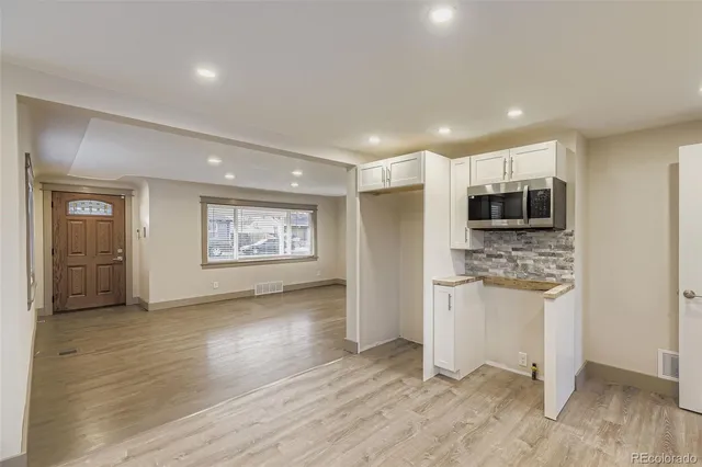a view of kitchen with stainless steel appliances kitchen island wooden floor and window
