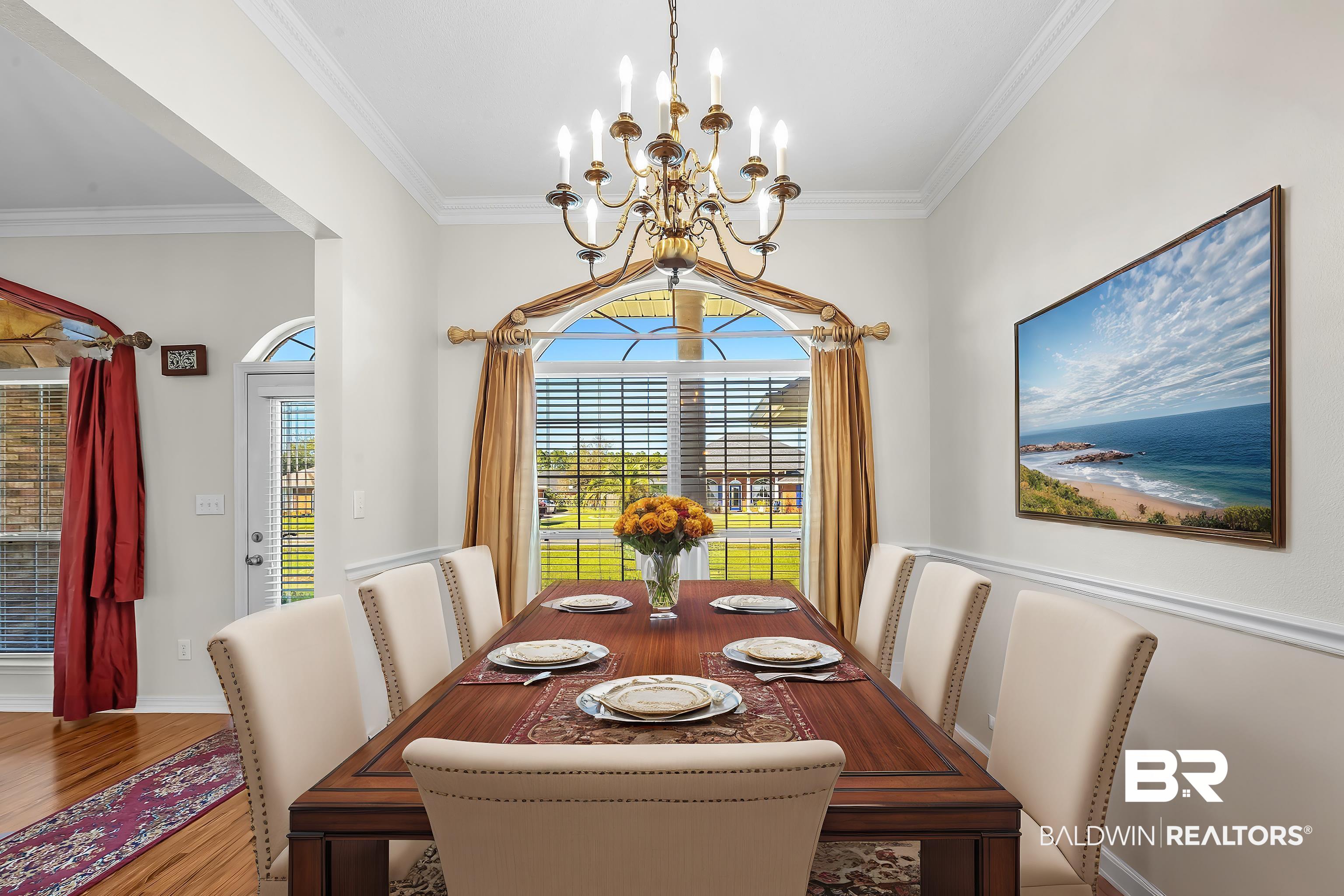421 Collinwood Loop Foley, AL 36535 - Photo 59 of 62 Dining space featuring a notable chandelier, hardwood / wood-style flooring, and crown molding