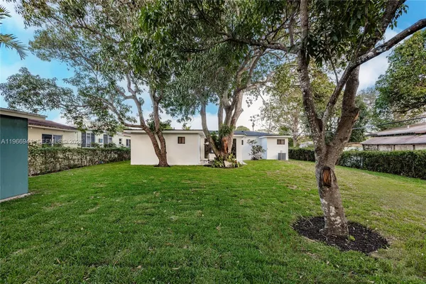 a view of a chair and table in backyard of the house