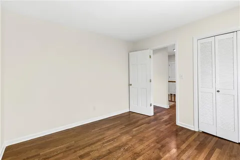 a view of an empty room with wooden floor
