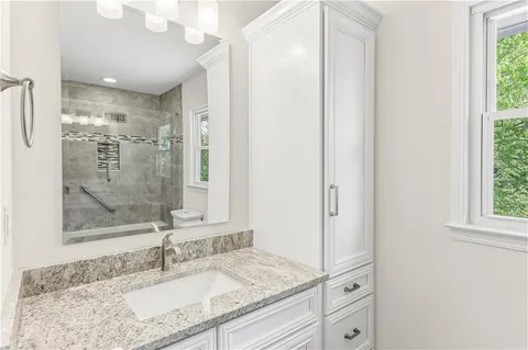 a bathroom with a granite countertop sink mirror and double
