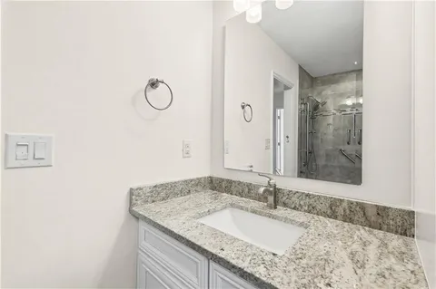 a bathroom with a granite countertop sink and a mirror
