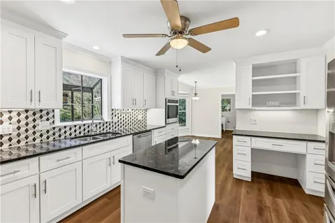 a kitchen with granite countertop stainless steel appliances sink stove and cabinets