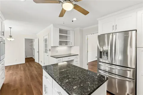 a kitchen with stainless steel appliances granite countertop a refrigerator a stove and a sink