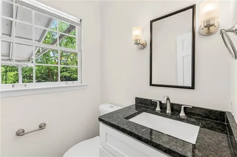 a bathroom with a granite countertop sink and a mirror