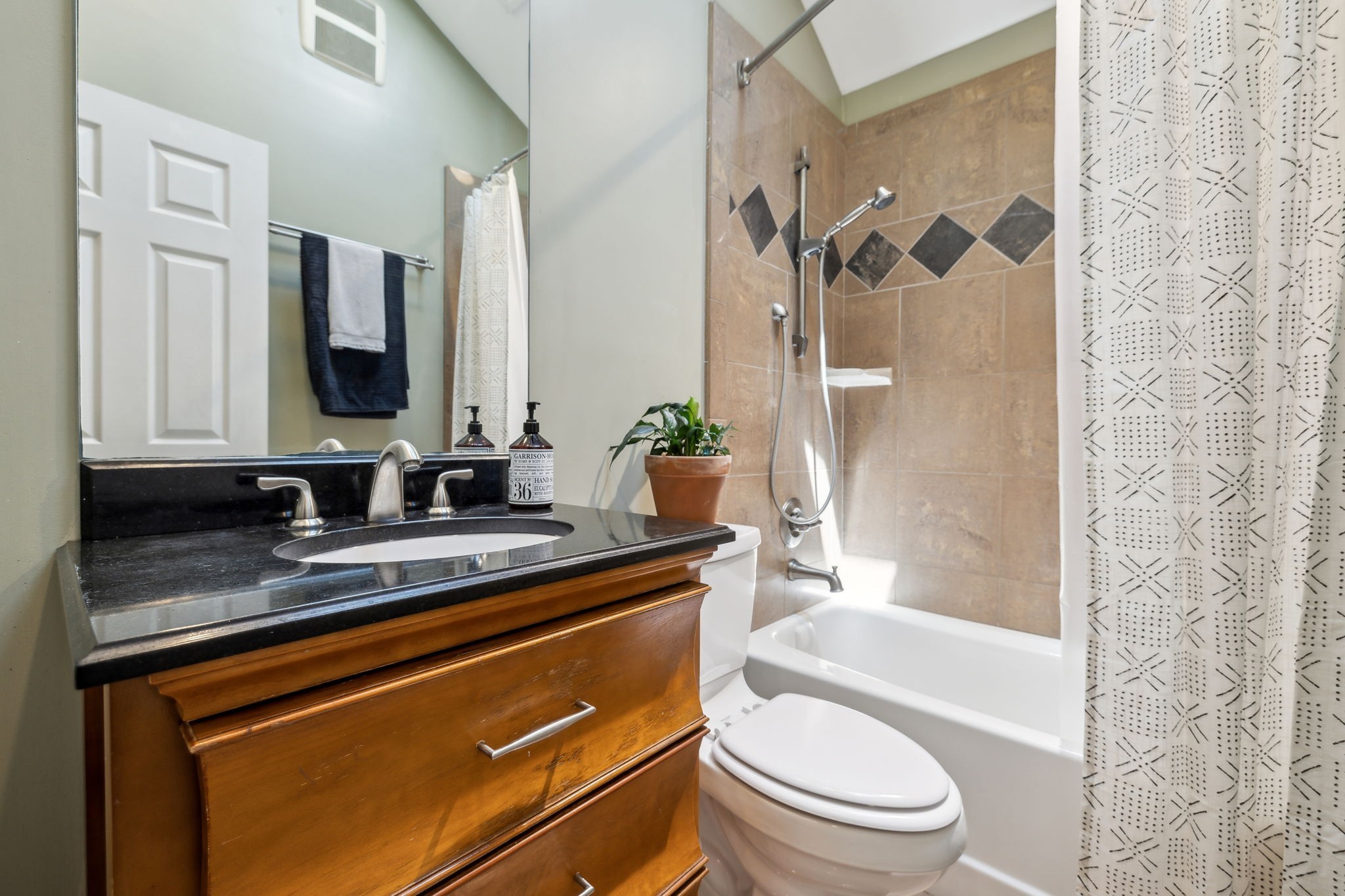 4202 Murphy Road Nashville, TN 37209 - Photo 13 of 34 a bathroom with a granite countertop sink toilet mirror and shower