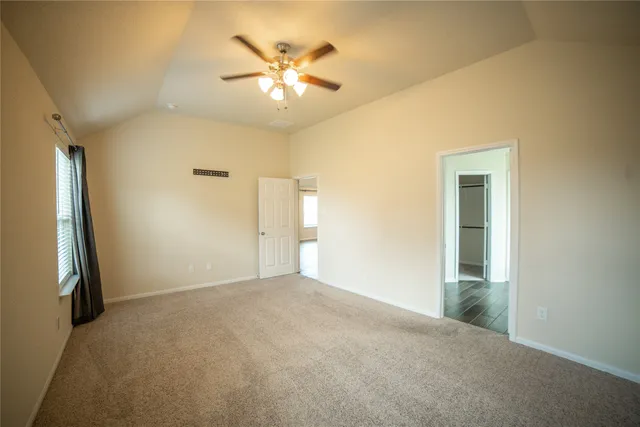 an empty room with a chandelier fan and a chandelier fan