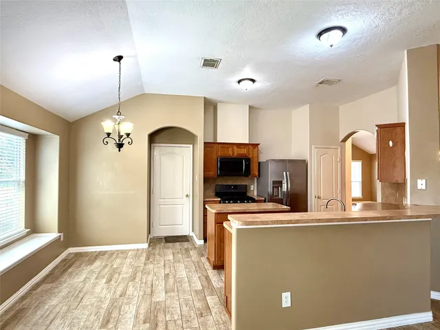 a view of a kitchen with a sink a refrigerator and window