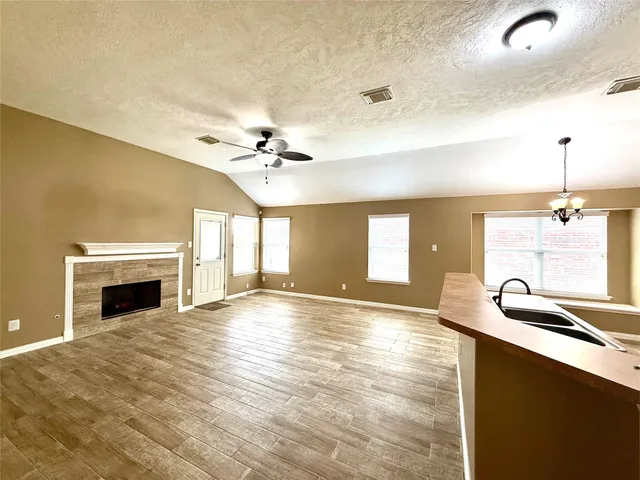 a view of an empty room with a fireplace and chandelier