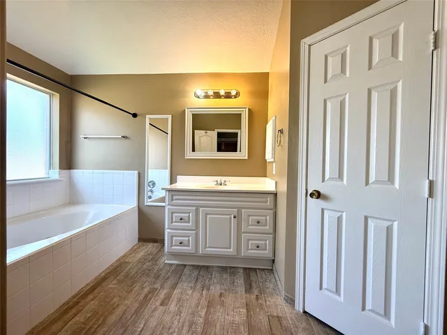 a bathroom with a granite countertop sink mirror and bathtub