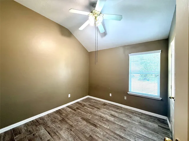 a view of a room with a ceiling fan and a window