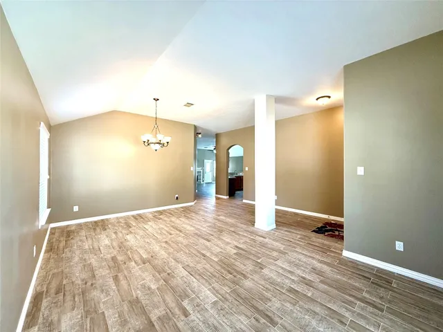 a view of a big room with wooden floor and windows