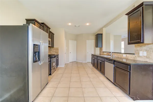 a kitchen with stainless steel appliances granite countertop a refrigerator and a sink