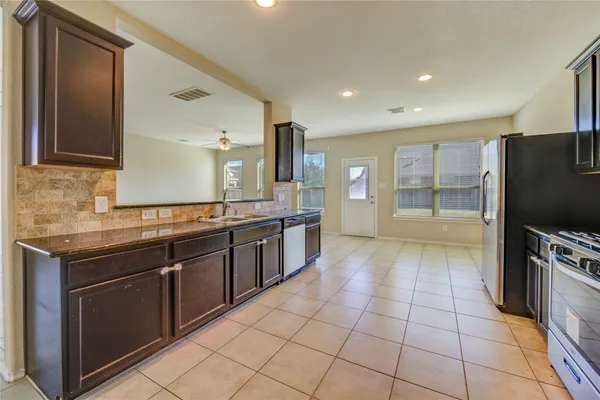 a large kitchen with stainless steel appliances granite countertop a large counter top and a stove top oven