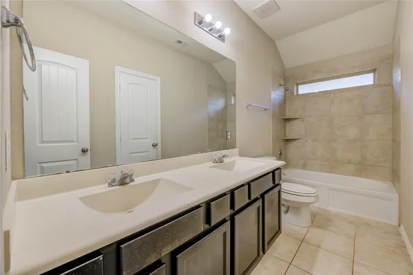a bathroom with a sink a toilet a mirror and shower