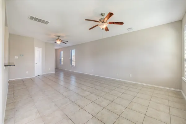 an empty room with windows and fan