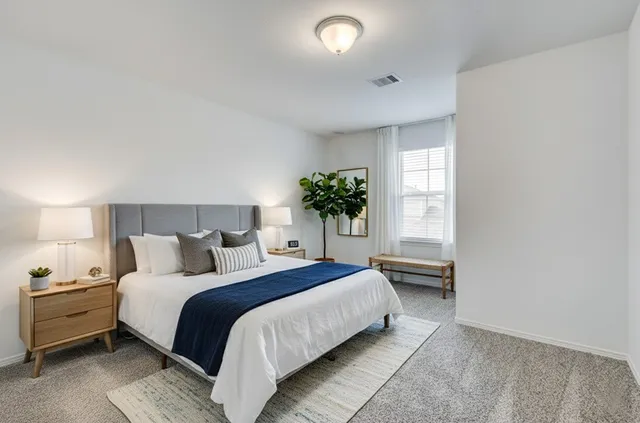 a spacious bedroom with a bed and a potted plant