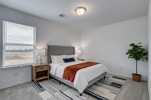 a bedroom with a bed and a potted plant
