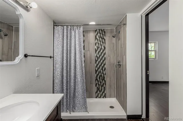 a bathroom with a shower a mirror and a sink