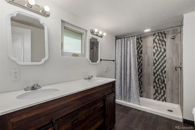 a bathroom with a double vanity sink mirror and shower