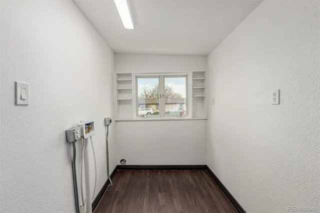 an empty room with wooden floor and a window