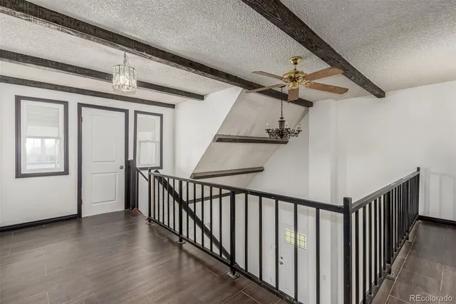 a view of a hallway with wooden floor and staircase