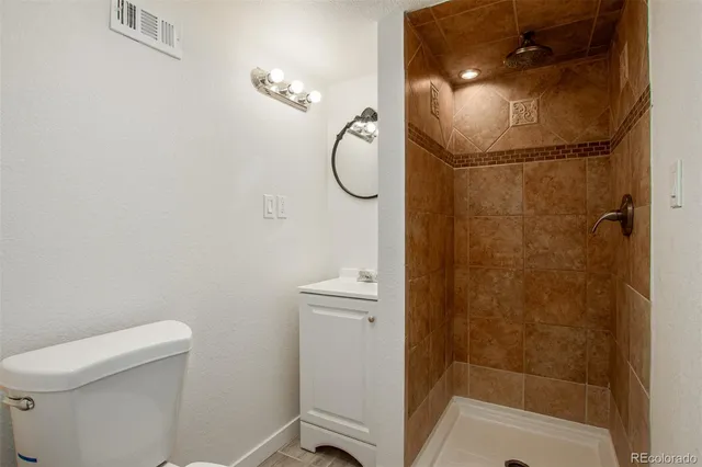 a bathroom with a granite countertop toilet and a sink