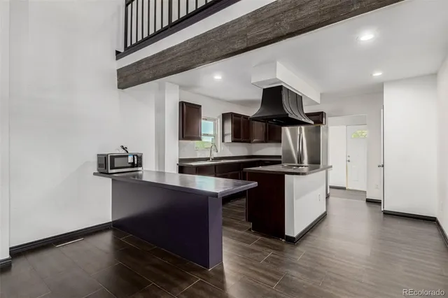 a kitchen with stainless steel appliances granite countertop a sink a stove and a wooden floors