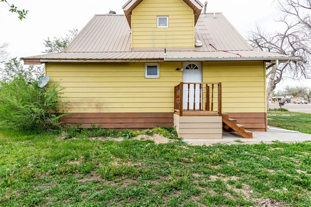 a view of a backyard with plants and a wooden fence