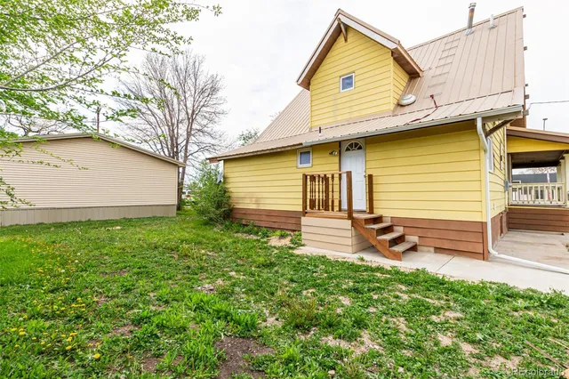 a view of a house with backyard and a tree