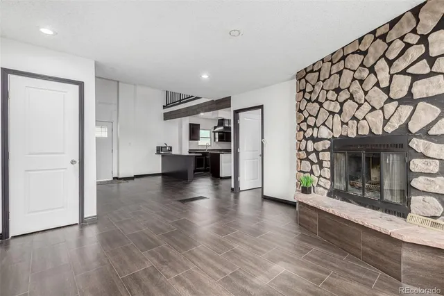 an empty room with wooden floor and a fireplace