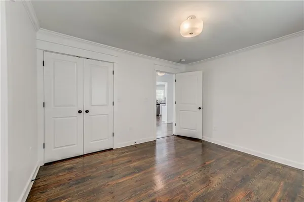 a view of an empty room with wooden floor