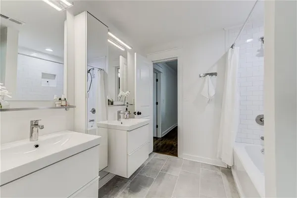 a bathroom with a double vanity sink a mirror and shower