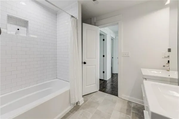 a bathroom with a tub a sink and a shower