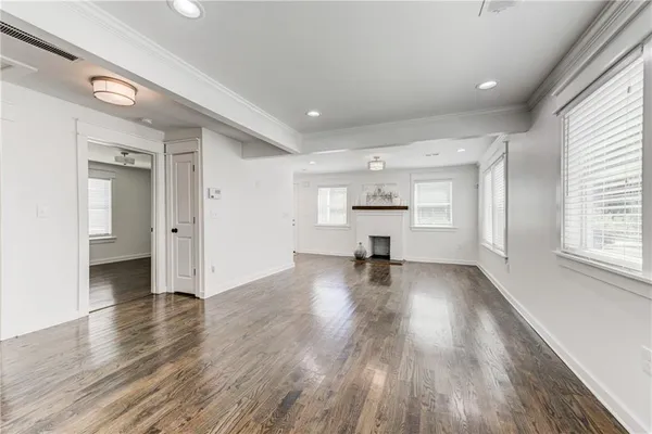 a view of empty room with wooden floor and window