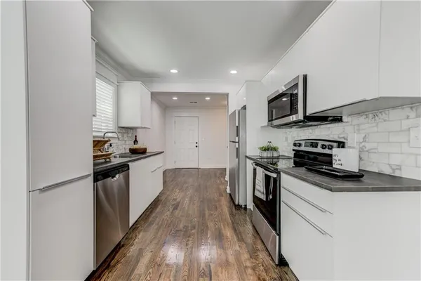 a kitchen with stainless steel appliances granite countertop a stove a sink and a refrigerator
