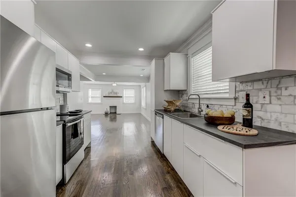 a kitchen with kitchen island a counter top space a sink stainless steel appliances and cabinets