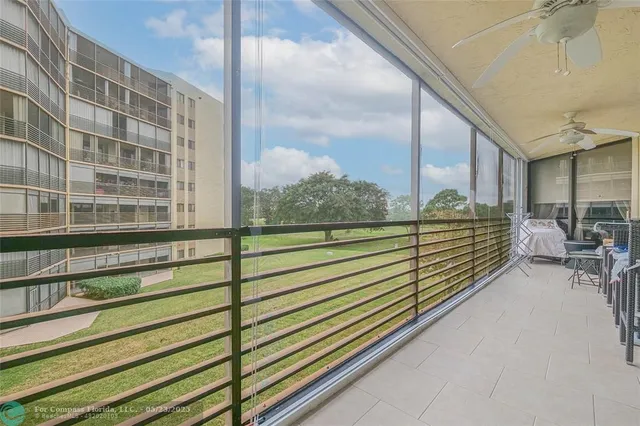 a view of a balcony with chairs and wooden fence
