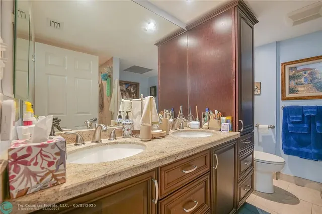 a bathroom with a granite countertop sink mirror and toilet
