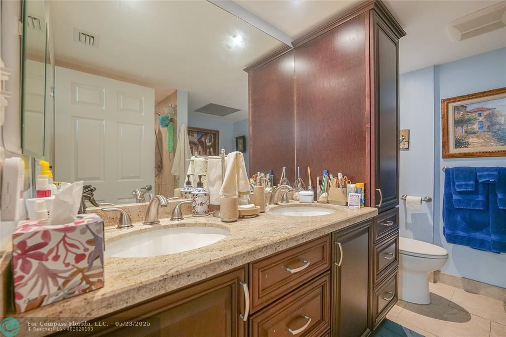 7300 Radice Court, Unit 302 Lauderhill, FL 33319 - Photo 27 of 81 a bathroom with a granite countertop double vanity sink toilet and a mirror